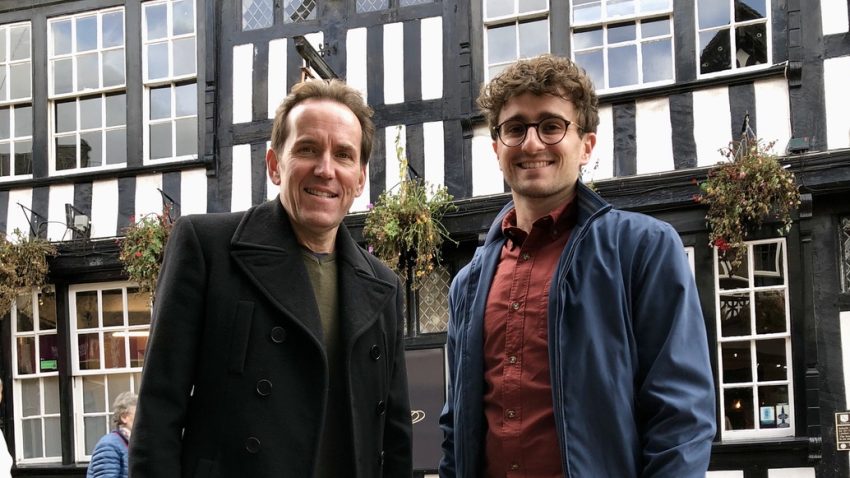 Two people stood in front of an Elizabethan house